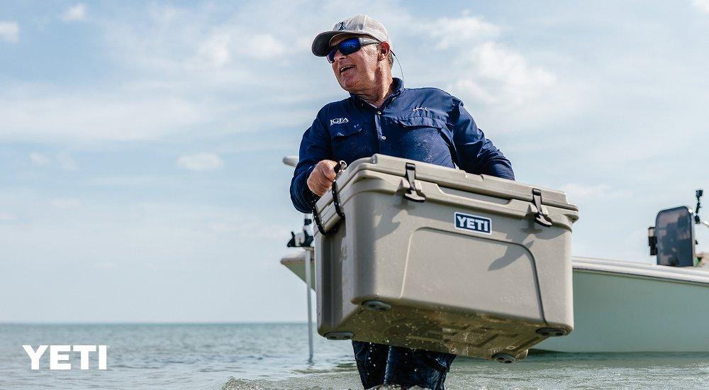 a guy hauling a YETI cooler from a fishing boat