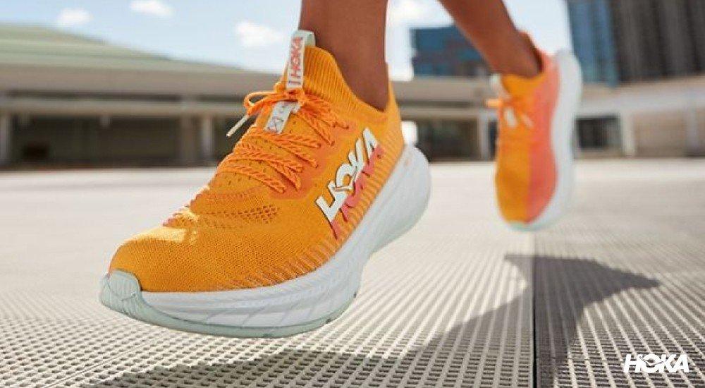 an orange hoka shoe with a carbon running plate