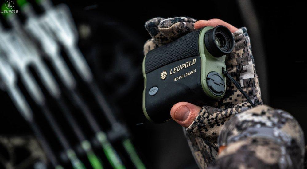 a hunter holding a hunting rangefinder
