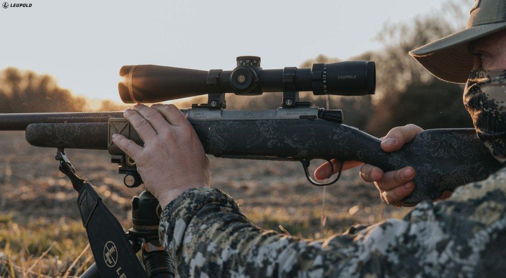 a hunter looking through a rifle scope when hunting
