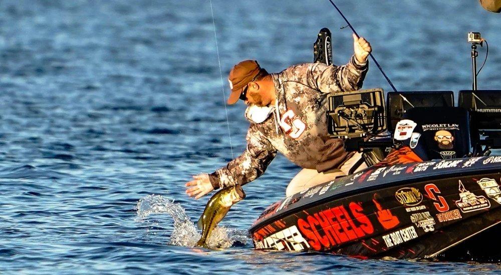 pat schlapper pulling a bass out of the water