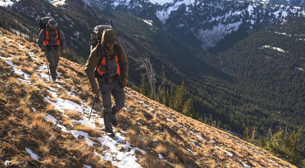 two hunters out walking on the mountainside