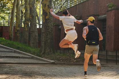 Woman running with a blue sky behind her