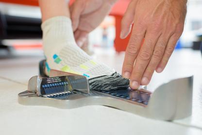 Person measuring their foot with a Brannock device