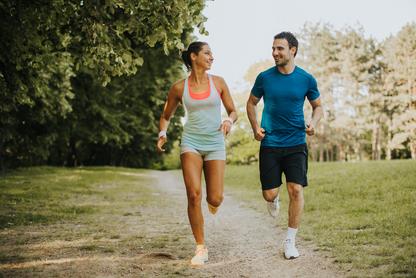 A woman and man running together in a park