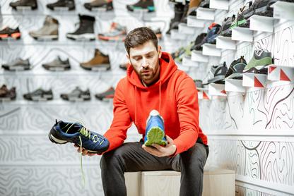 Man deciding between two different running shoes