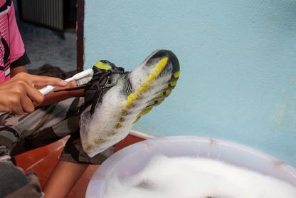 Man cleaning dirty shoes with a brush