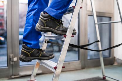 Person in work boots climbing a ladder
