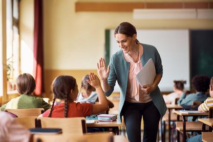 Teacher high fiving a student in their classroom