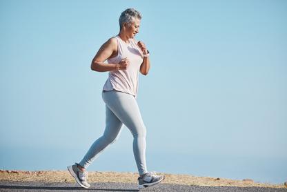 Woman running with blue sky behind her