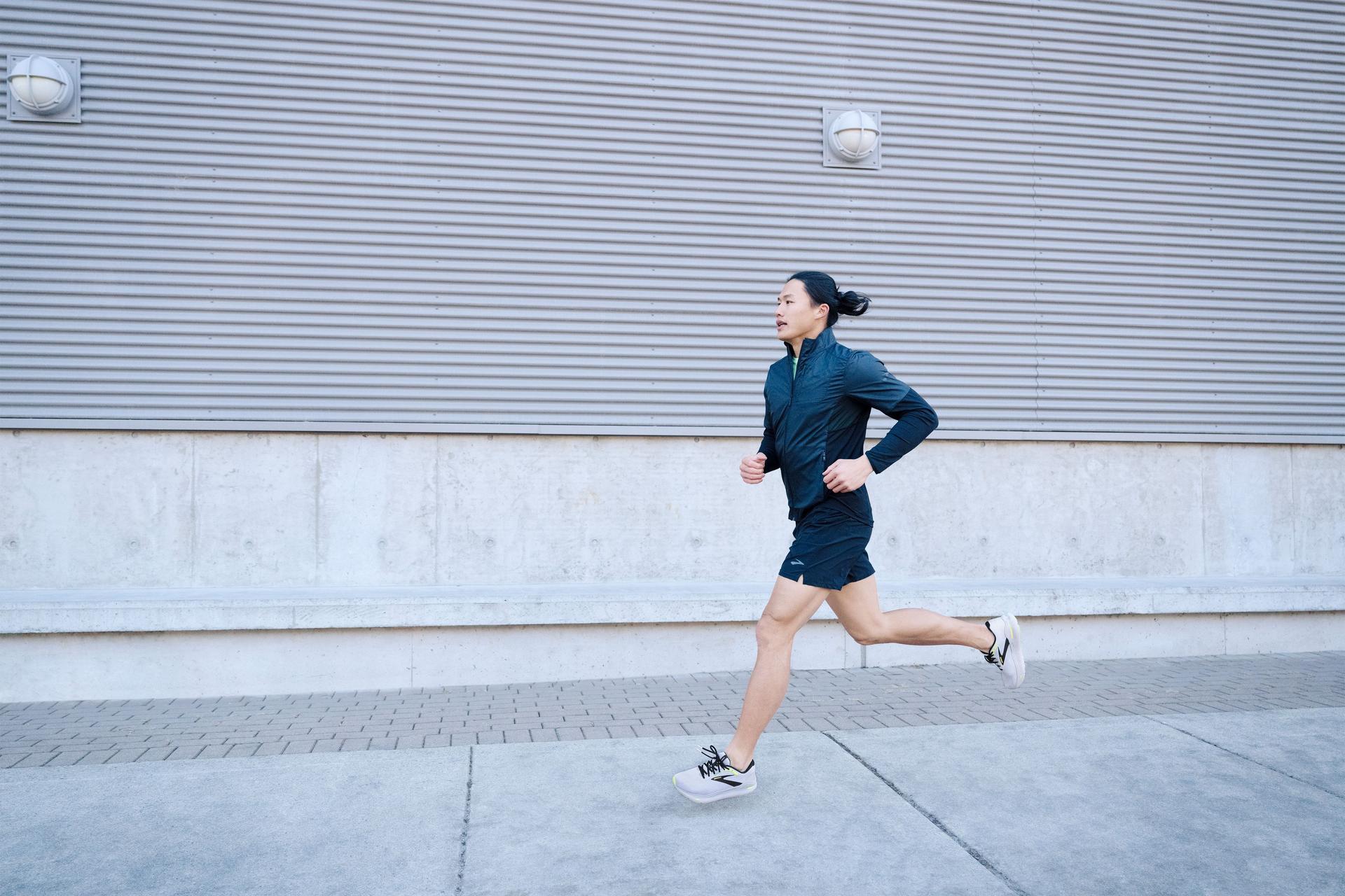 Person running wearing Brooks Ghost Max shoes on a street