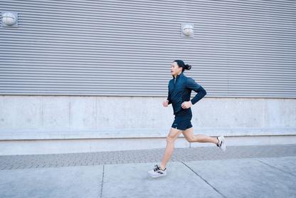 Person running wearing Brooks Ghost Max shoes on a street