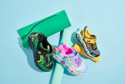 Three kids shoes laying on a blue background