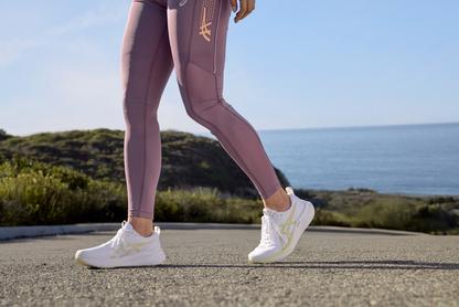 Woman in purple leggings walking in sneakers