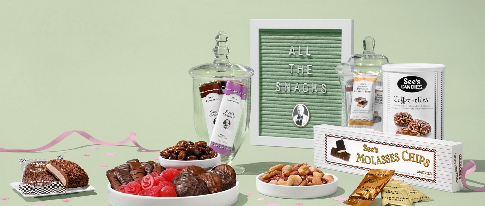 Frame that reads "All The Snacks" next to a variety of chocolate on a pastel green background