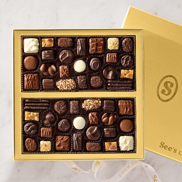 An open box of chocolates is seen with a gold lid.