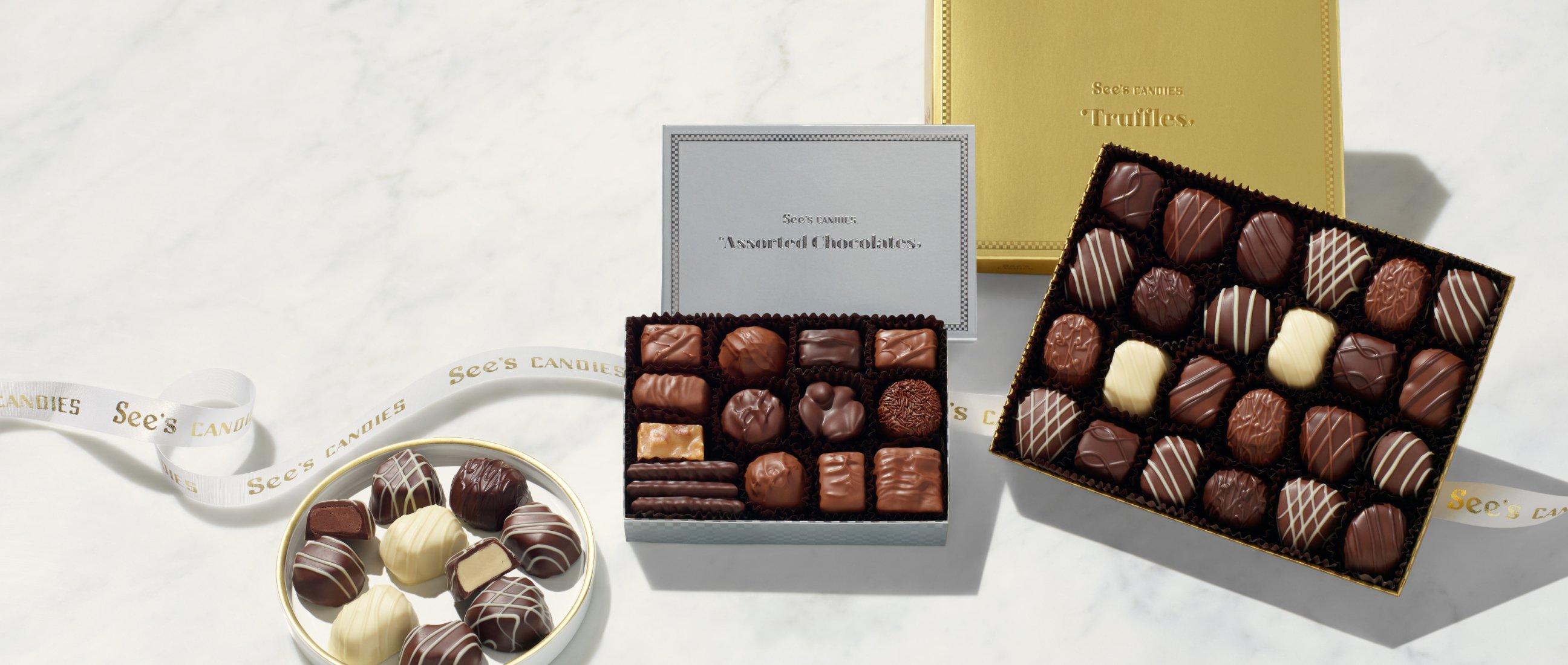 A silver box of chocolates and a gold box of chocolates