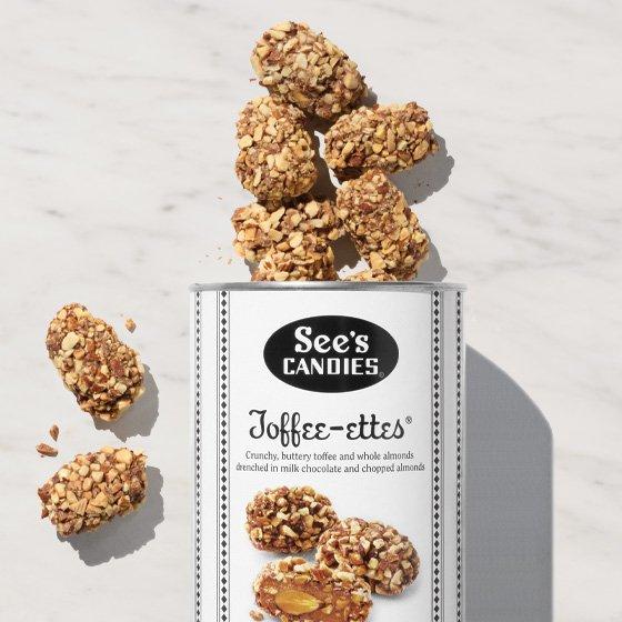 A can of See's Candies Toffee-ettes is seen with candy spilling out.