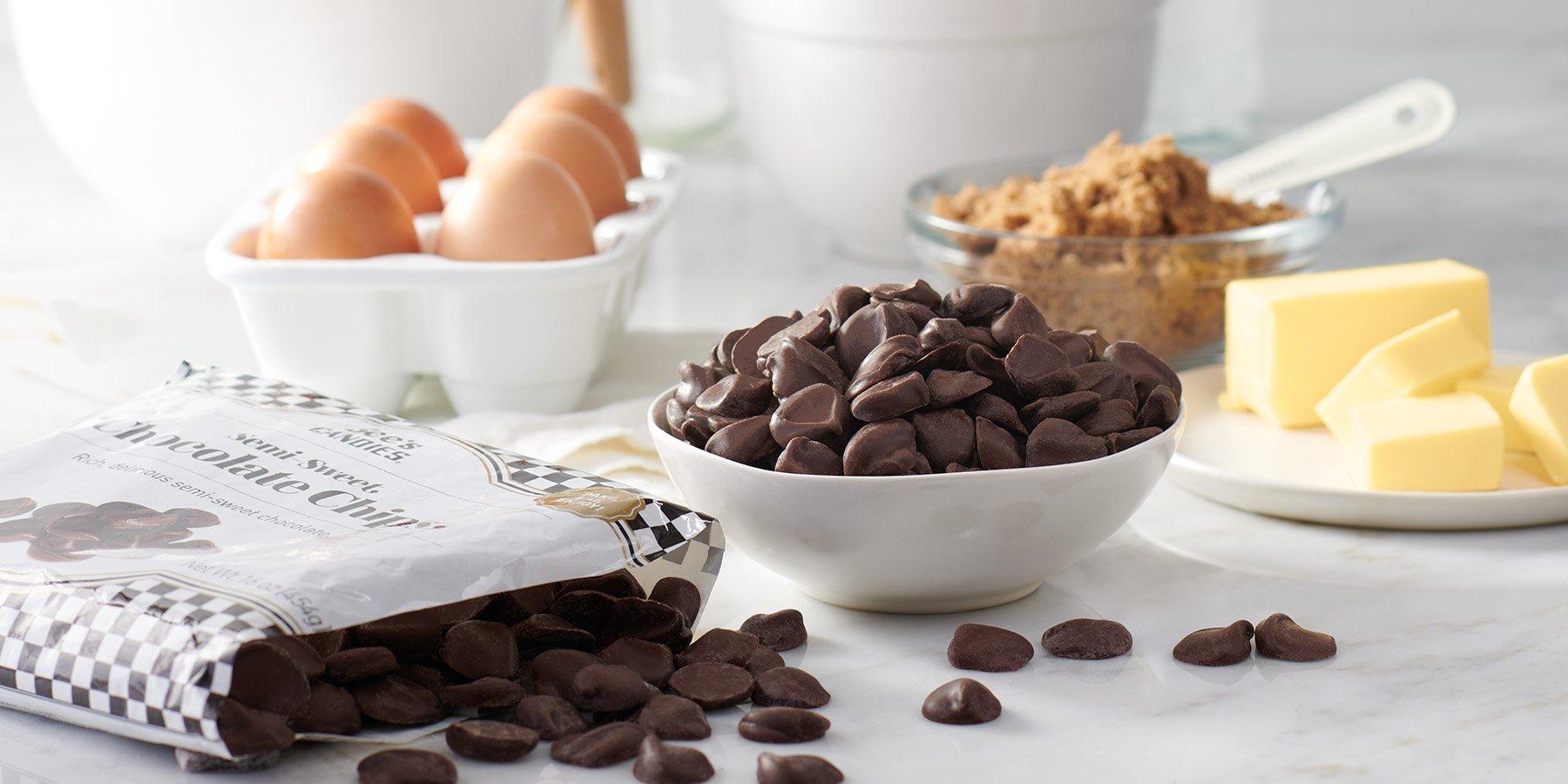 A marble countertop with baking ingredients like butter, egg, sugar, and chocolate chips