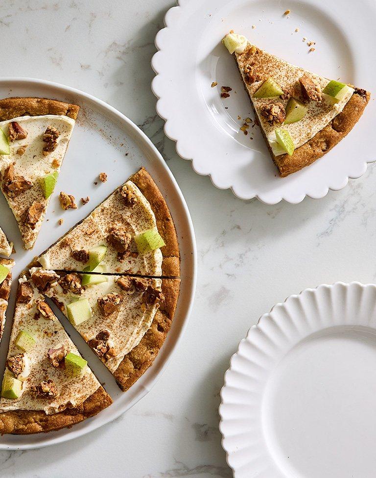 Chocolate chip cookie pizza on a plate with a cut slice on the side