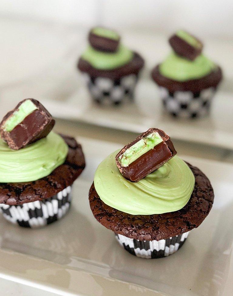 Chocolate cupcakes with mint green frosting topped with a Dark Mint Scotchmallow piece