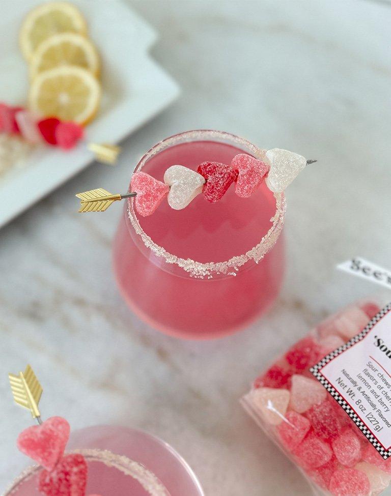 A pink beverage with a garnish of sour hearts