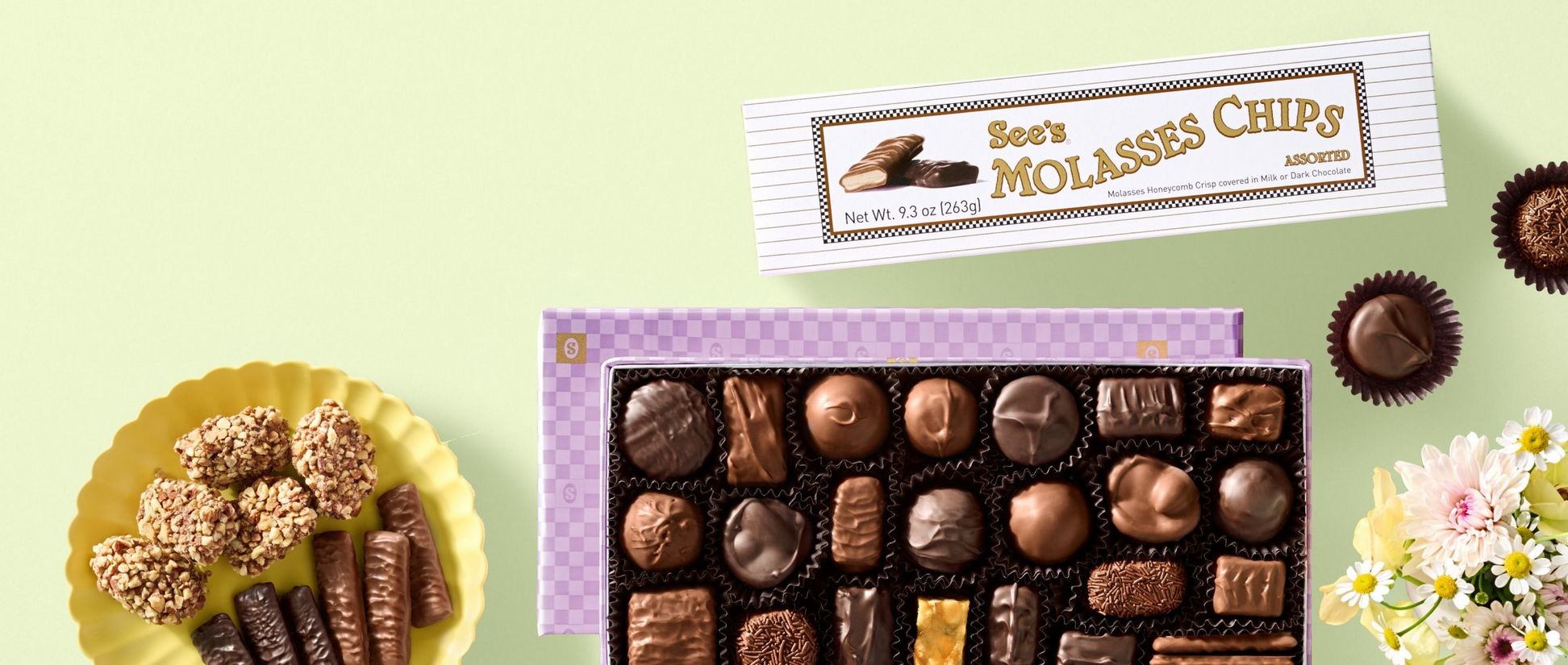 A box of molasses chips and nuts & chews next to a candy dish