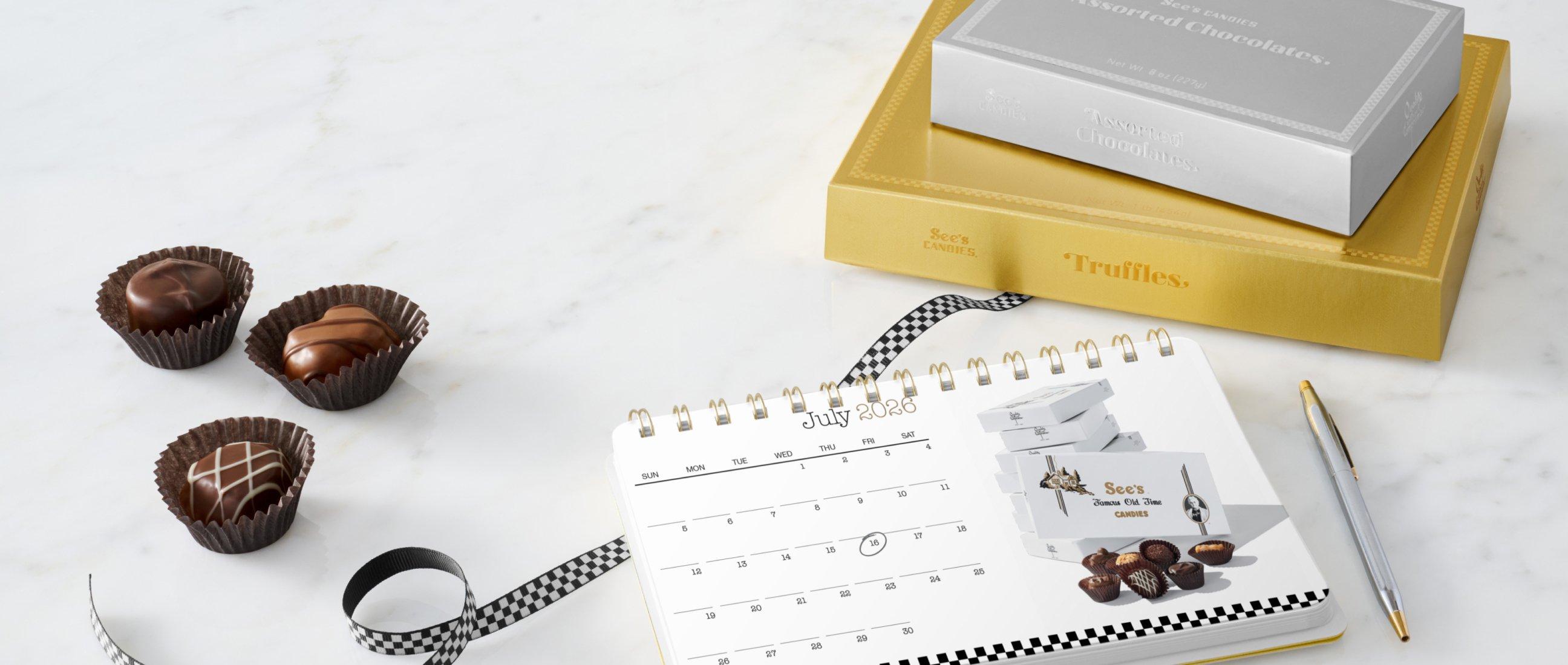 A stack of boxed chocolates with a calendar.