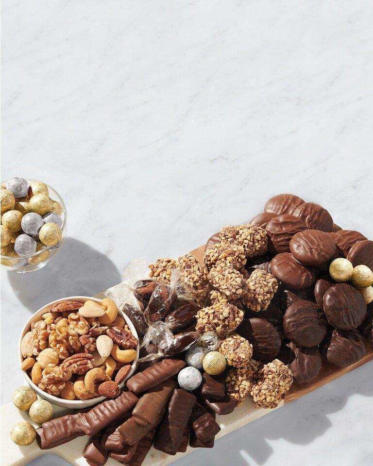 A charcuterie board loaded with See's Candies and treats.