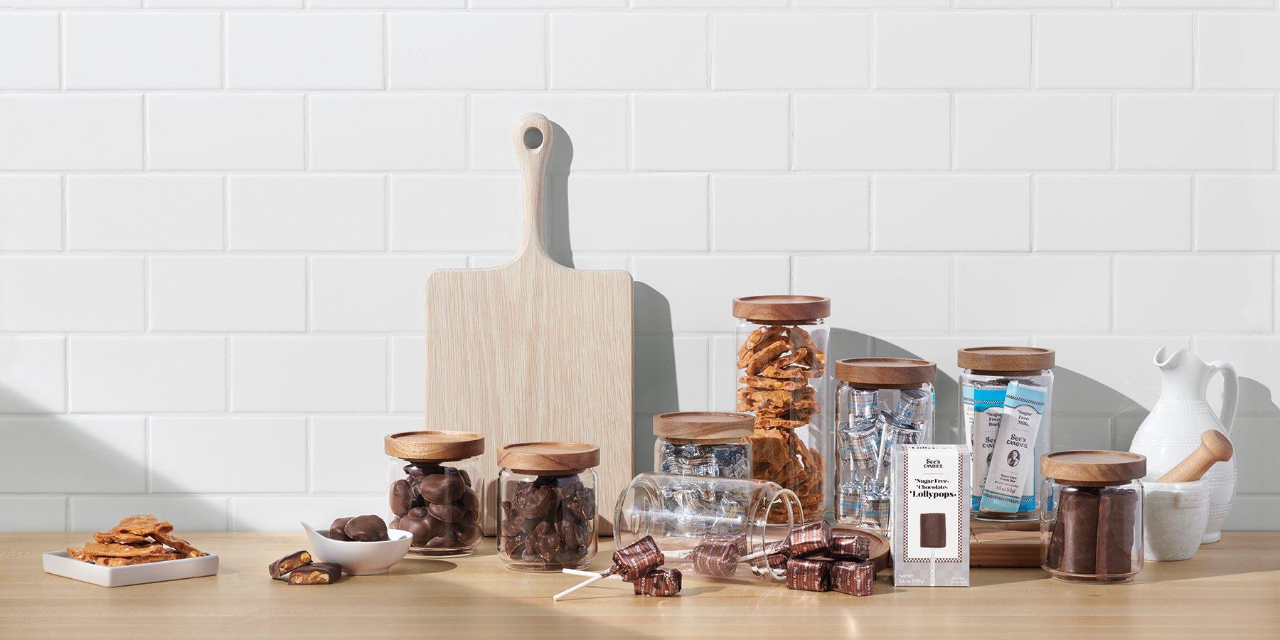 Various chocolates, lollipops, peanut brittle in storage jars