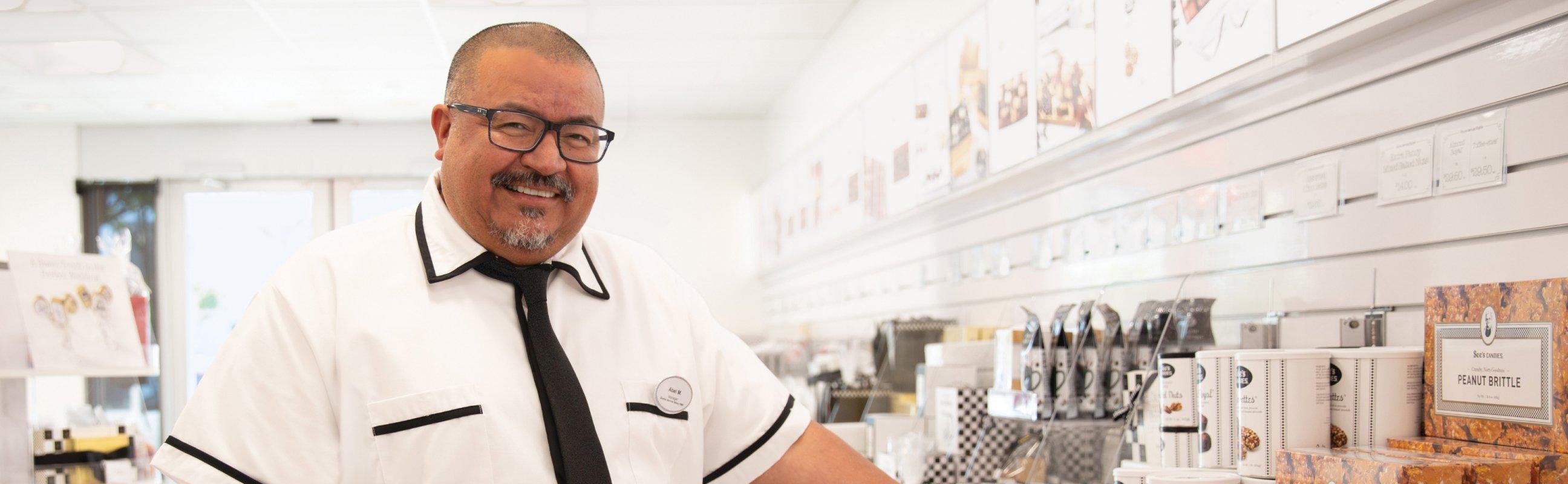 Happy See's Candies Salesperson in a shop.