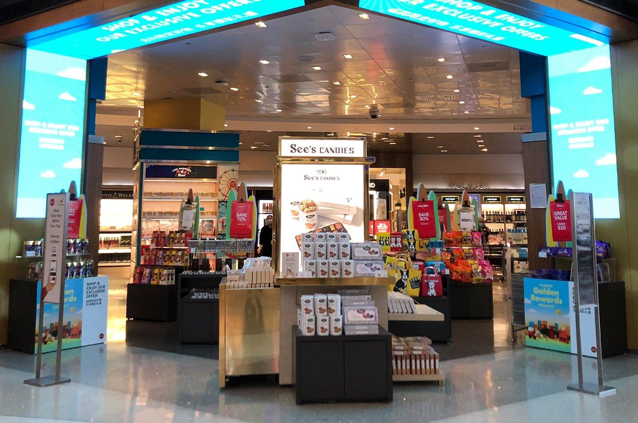 A See's Candies kiosk is diplayed in mall storefront.