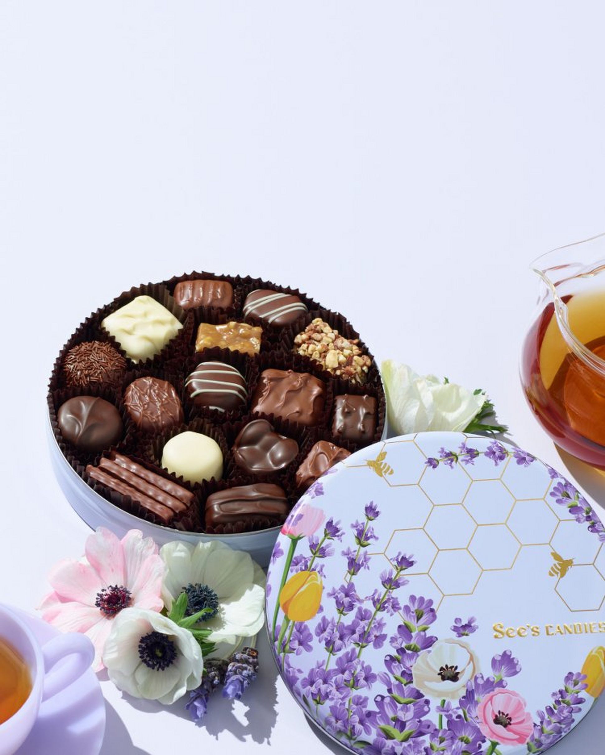 A circular tin decorated with lavender florals filled with chocolates