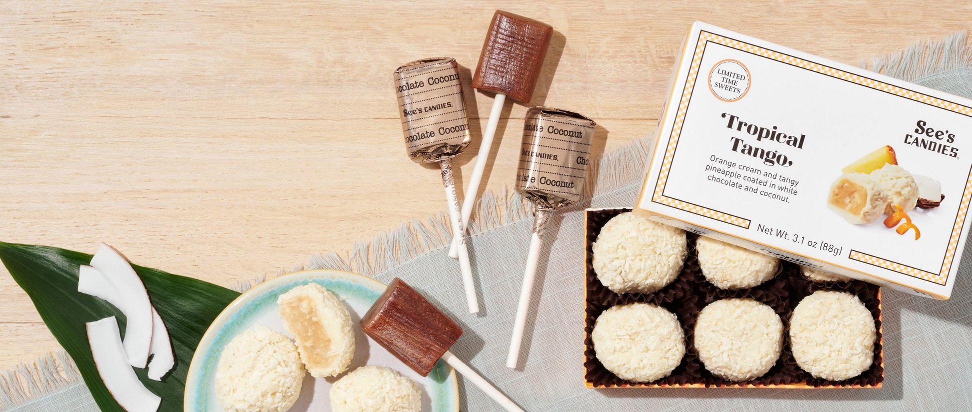 An open box of tropical tango chocolates and some chocolate coconut lollypops