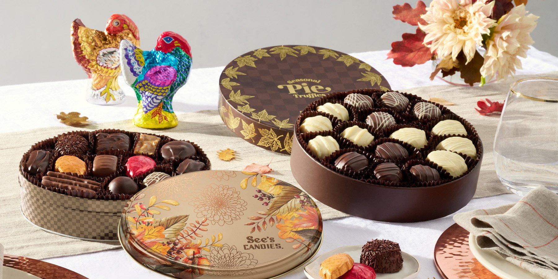 A display of See's Candies fall themed chocolate boxes and chocolate turkeys on a fall tablescape.
