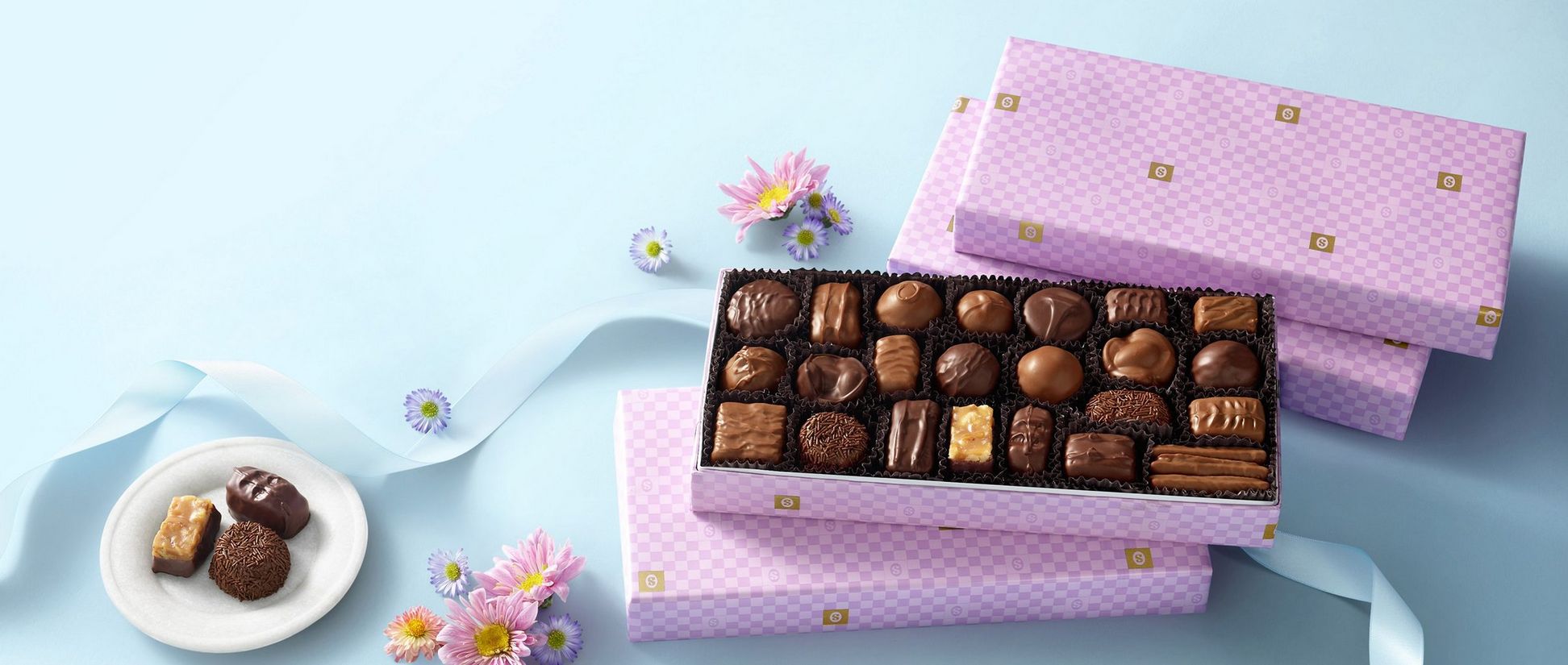 Stacked boxes of chocolate in lavender gift wrapping