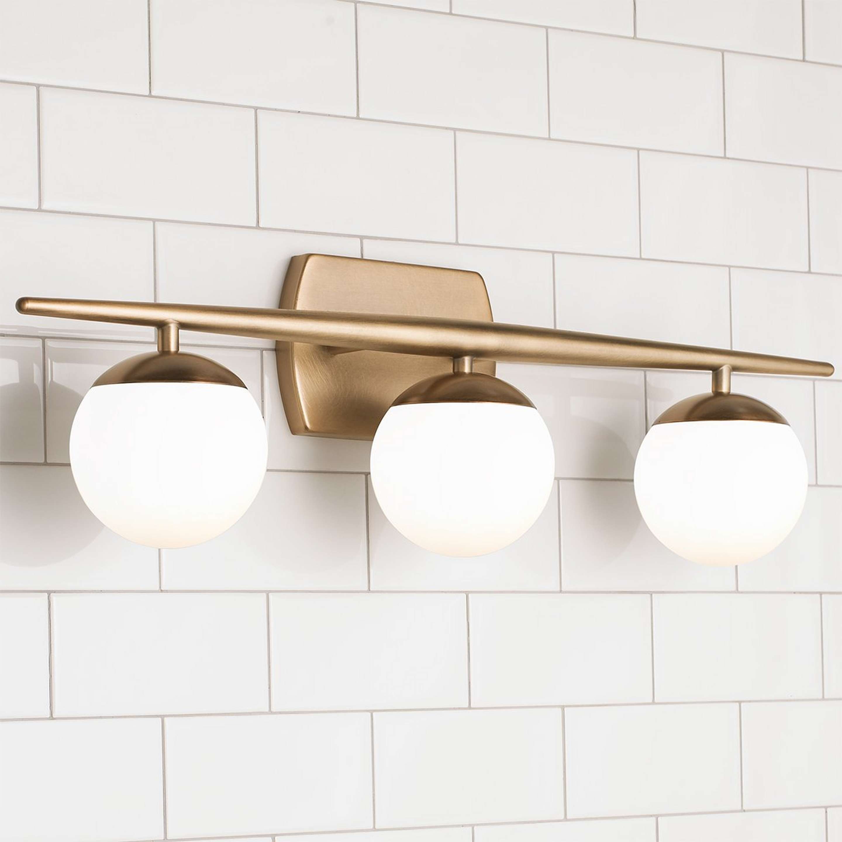 A Linear Globe Vanity Light - 3 Light with Natural Brass color
