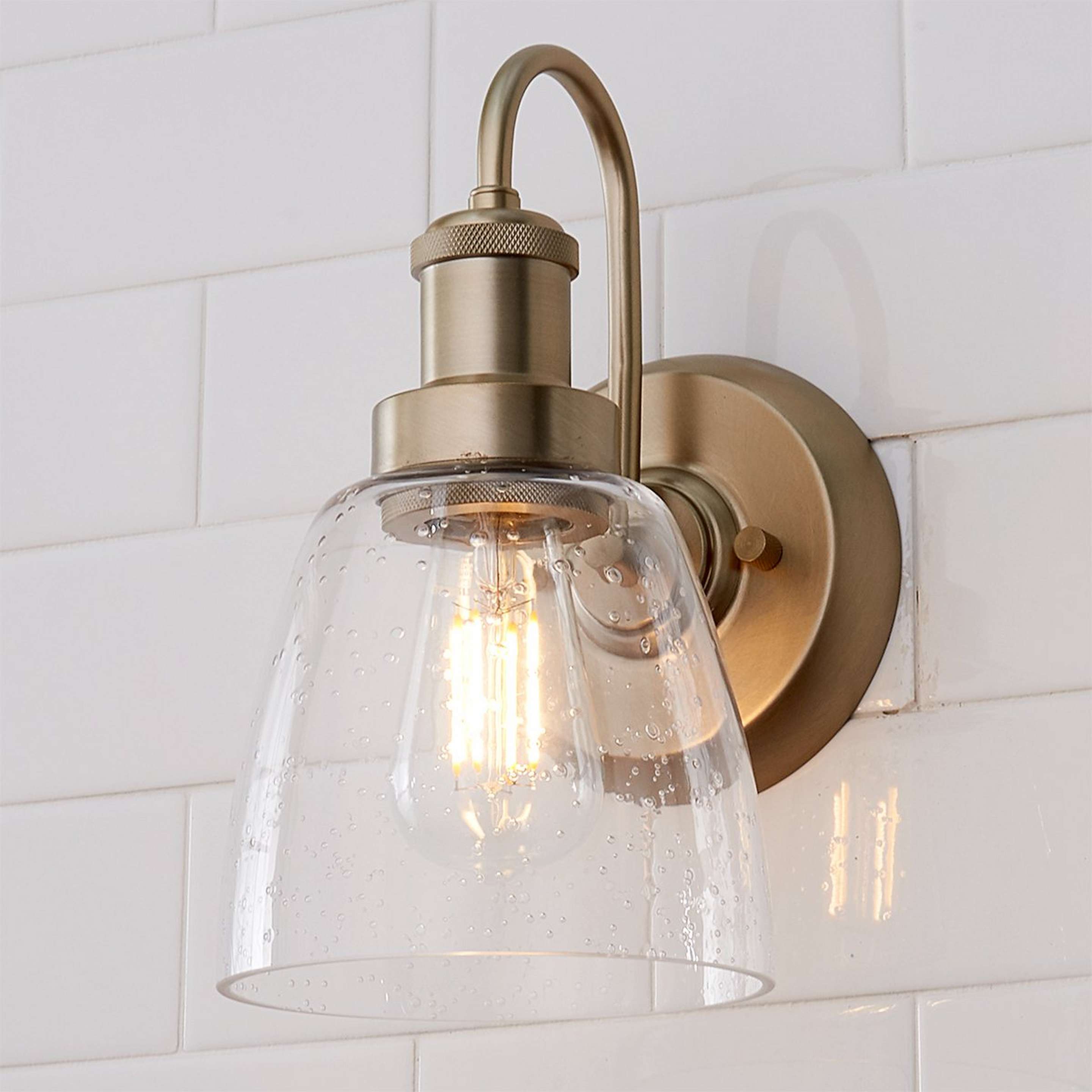 A Versatile Bath Sconce with Aged Brass / Clear Seeded Glass color