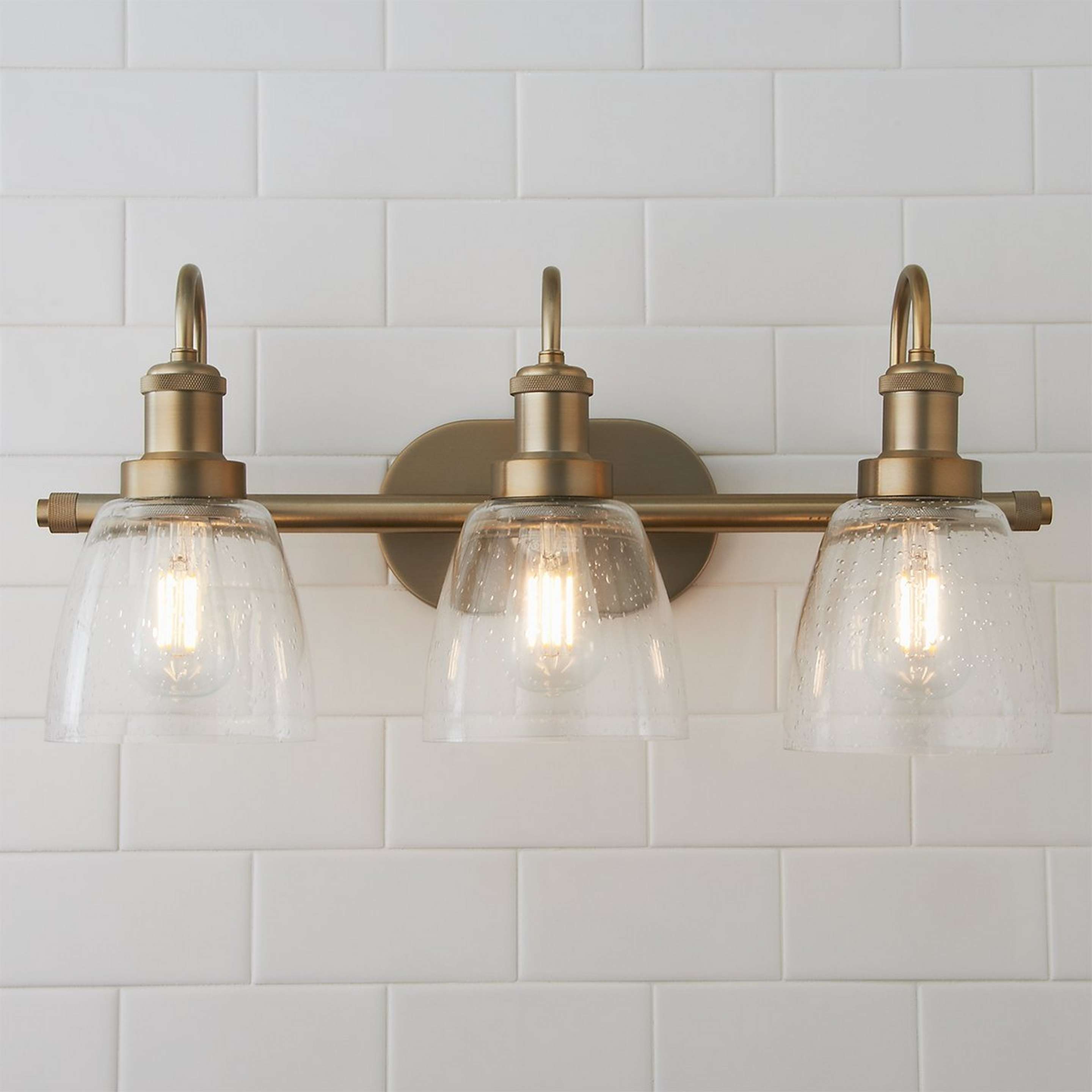 A Versatile Vanity Light - 3 Light with Aged Brass / Clear Seeded Glass color