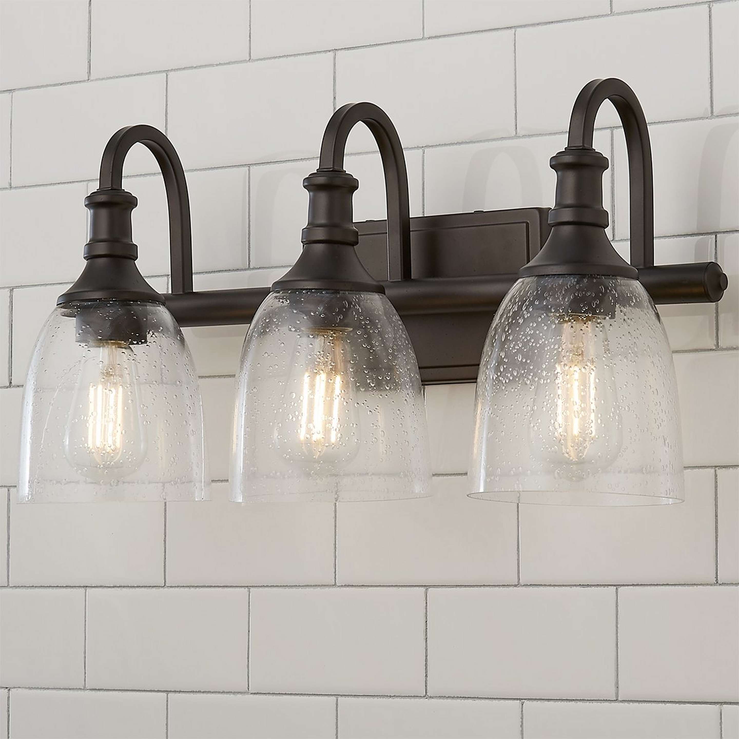 A Modern Progression Vanity Light - 3 Light with Oiled Bronze / Clear Seeded color