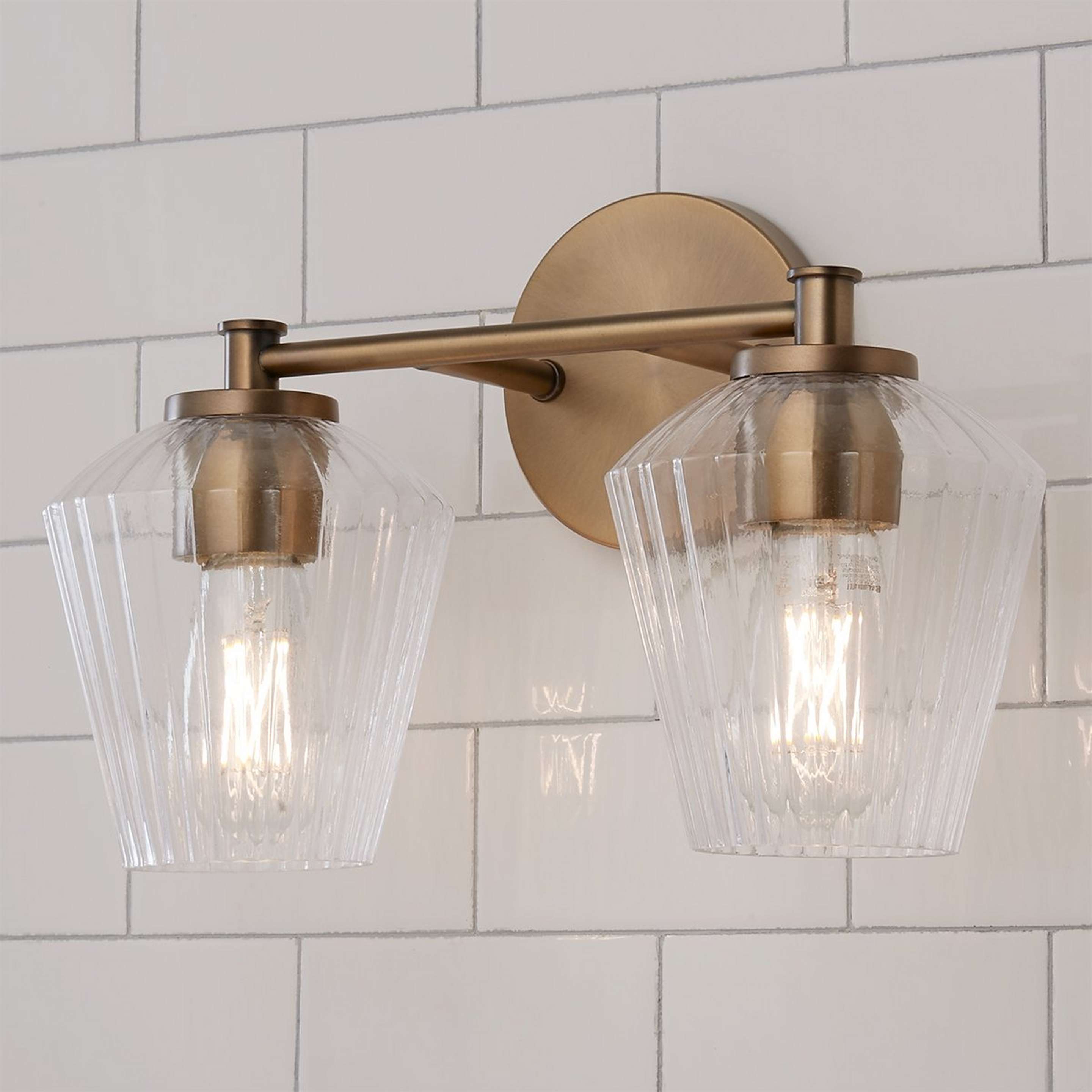 A Fluted Felix Vanity Light - 2 Light with Aged Brass / Clear Fluted Glass color