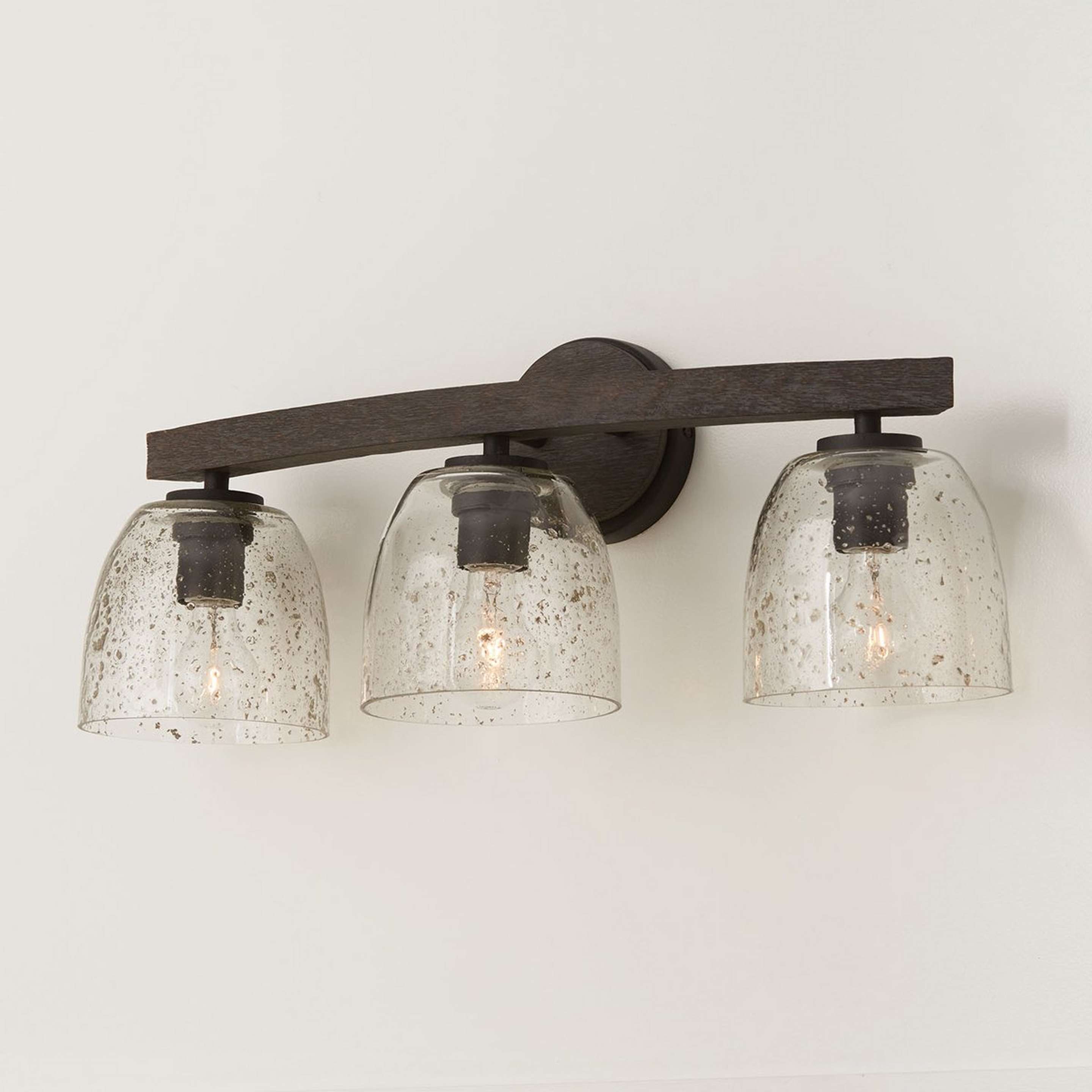 A Byerton Vanity Light - 3 Light with Iron / Carbon Gray Wood / Seeded Glass color