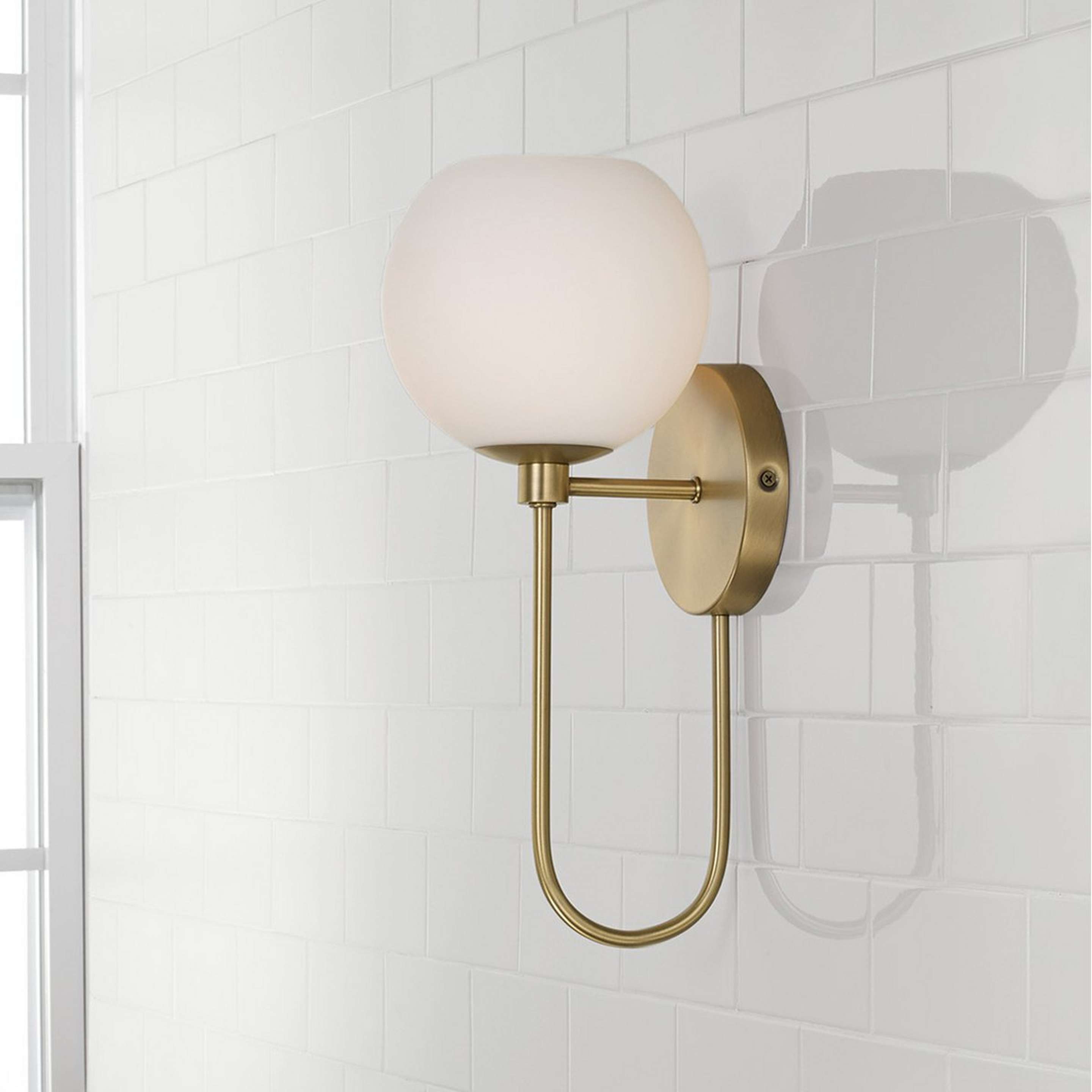 A Coda Bath Sconce with Aged Brass / White Glass color