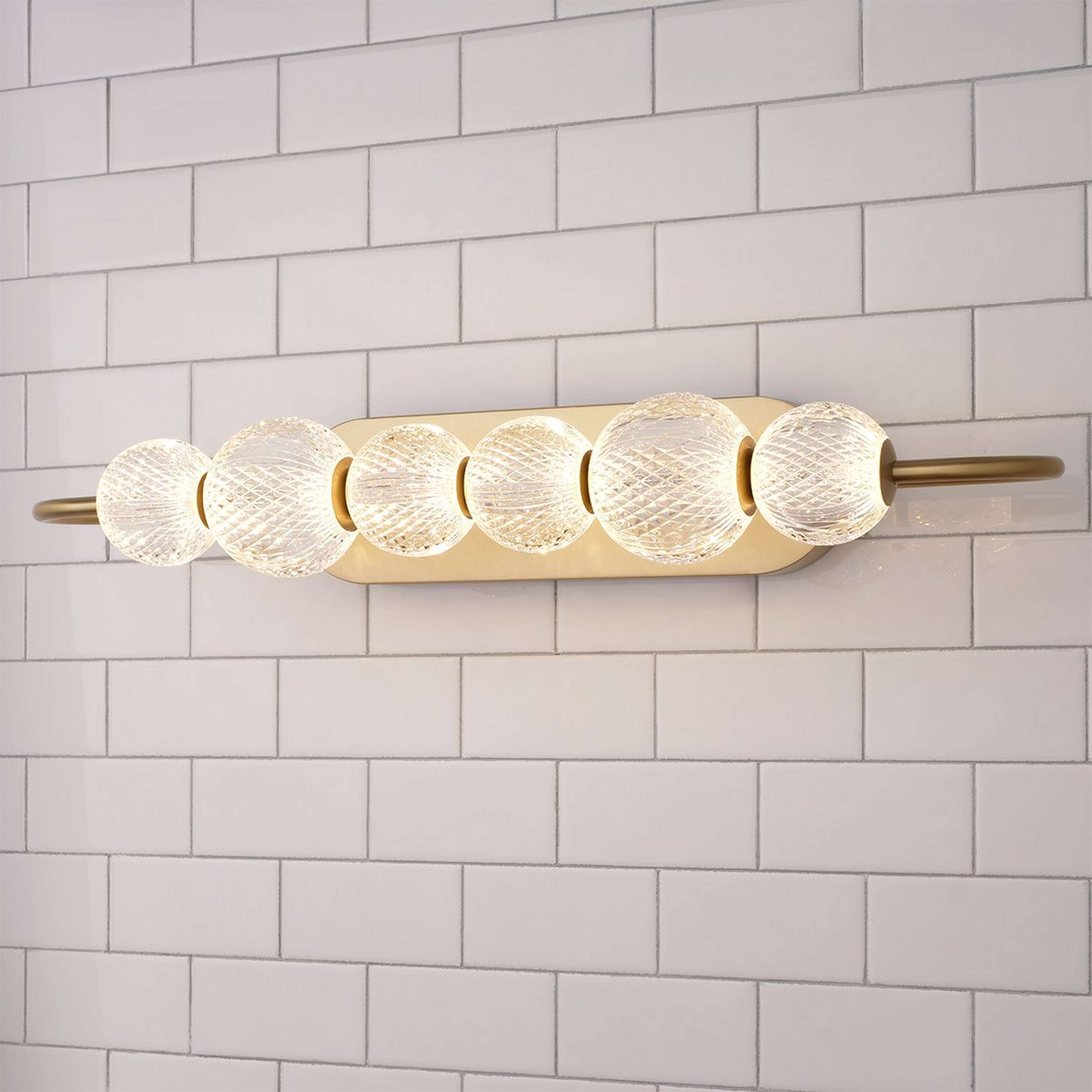 A Pearlstrung LED Bath Sconce with Aged Brass / Faceted Clear Acrylic color