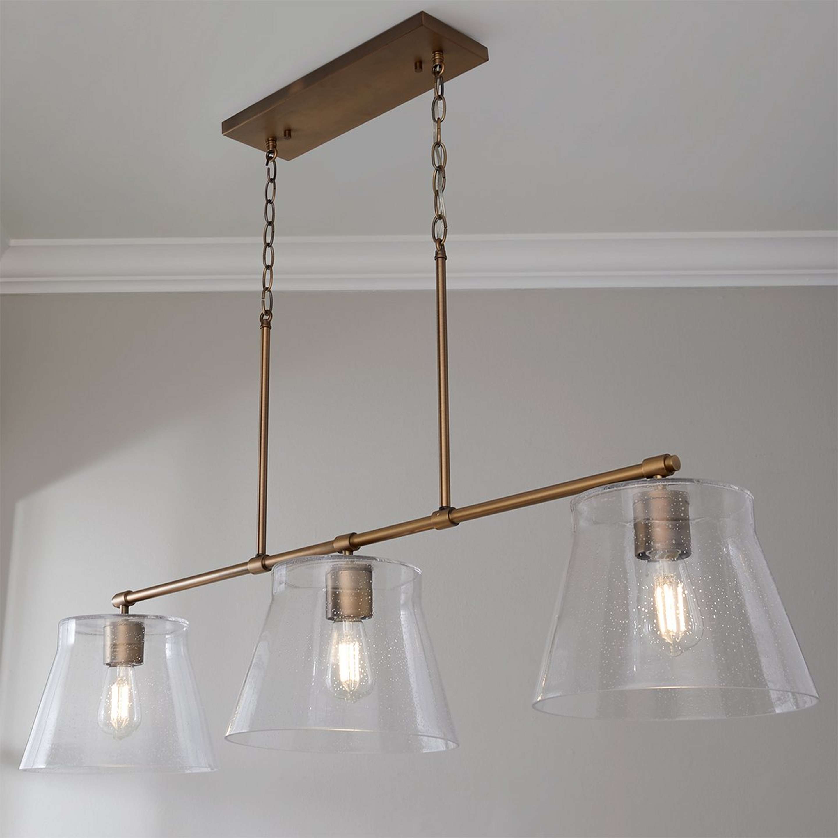 A Davalyn Island Chandelier with Aged Brass / Seeded Glass color