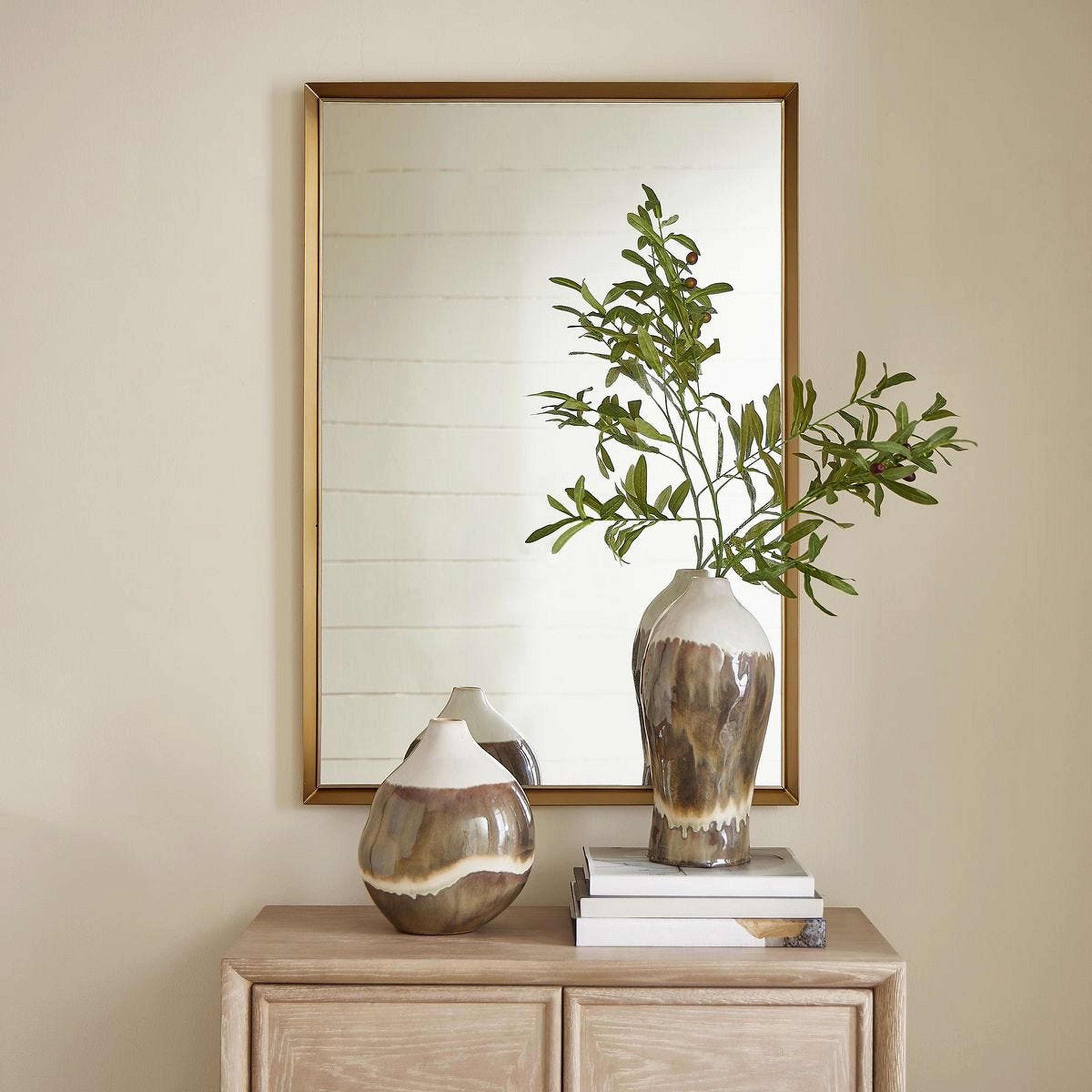 A Caleb Mirror with Brushed Brass color