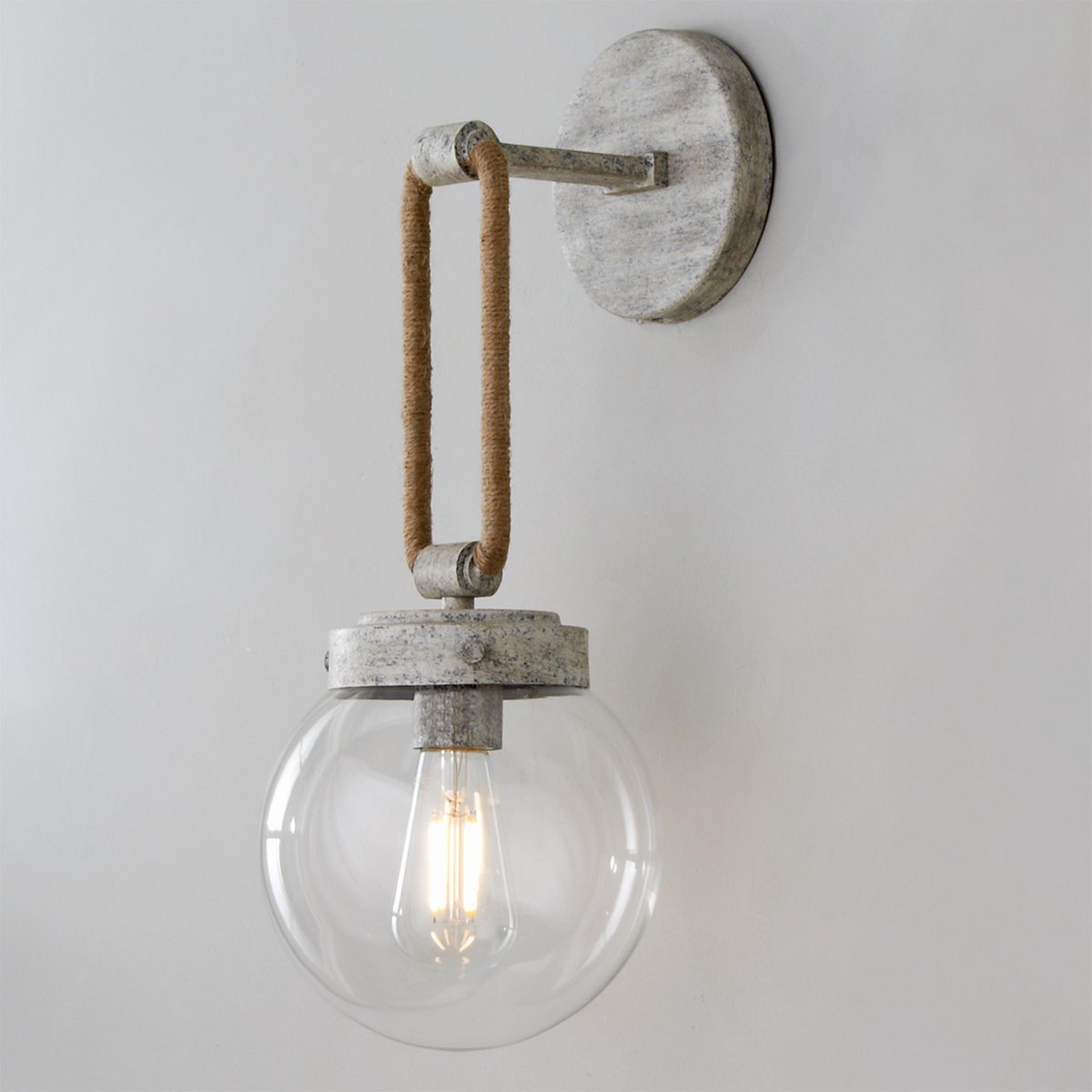 A Coastal Cottage Rope Globe Sconce with Distressed Cream color