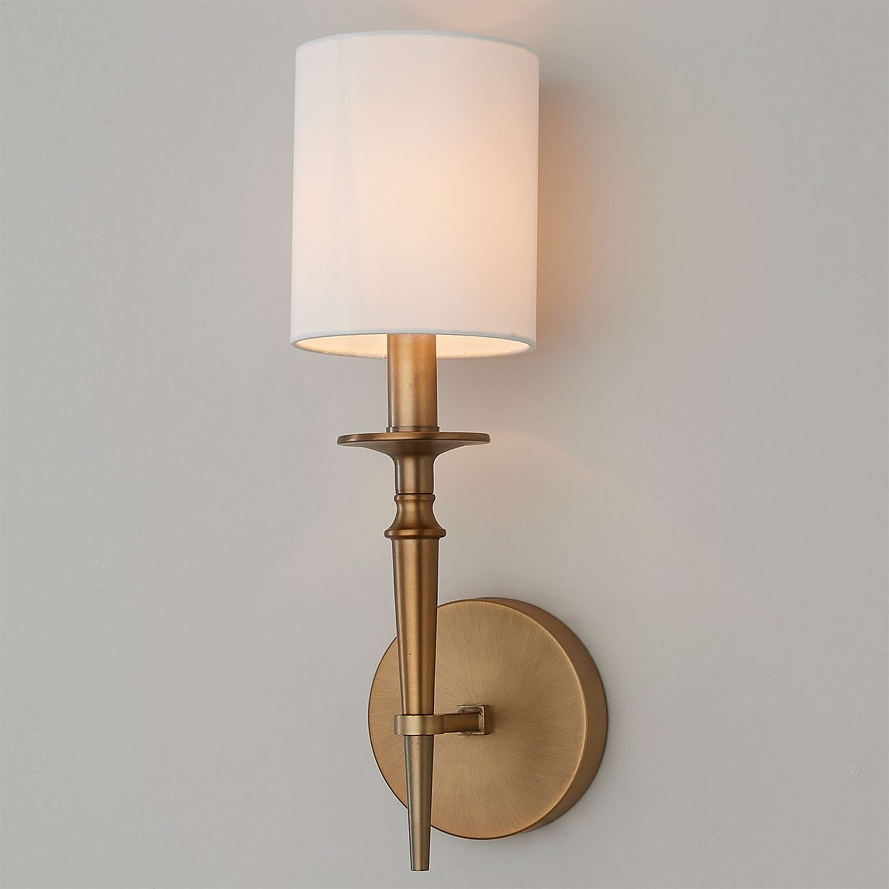 A Bella Sconce with Aged Brass color