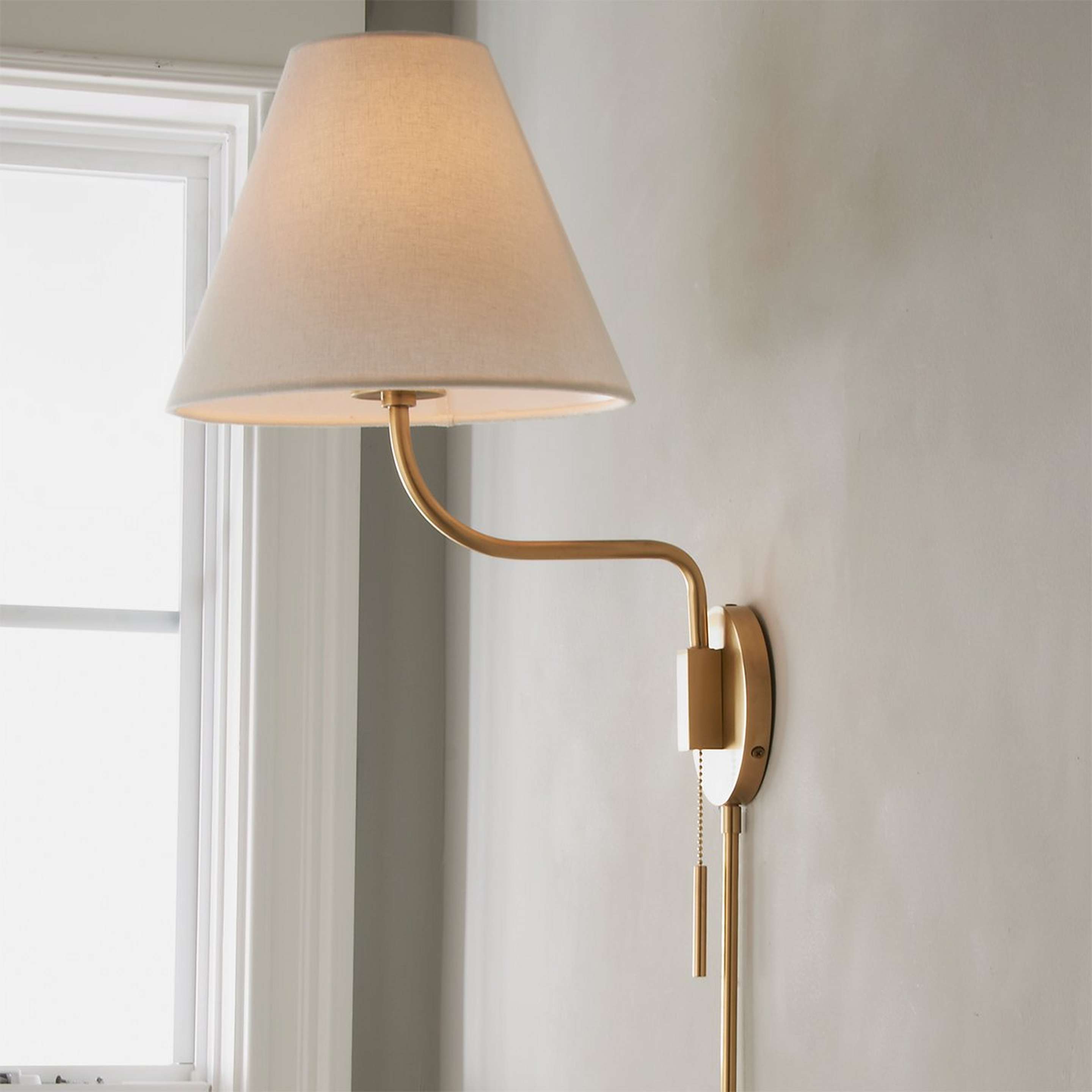 A Transitional Swing Arm Sconce with Aged Brass color
