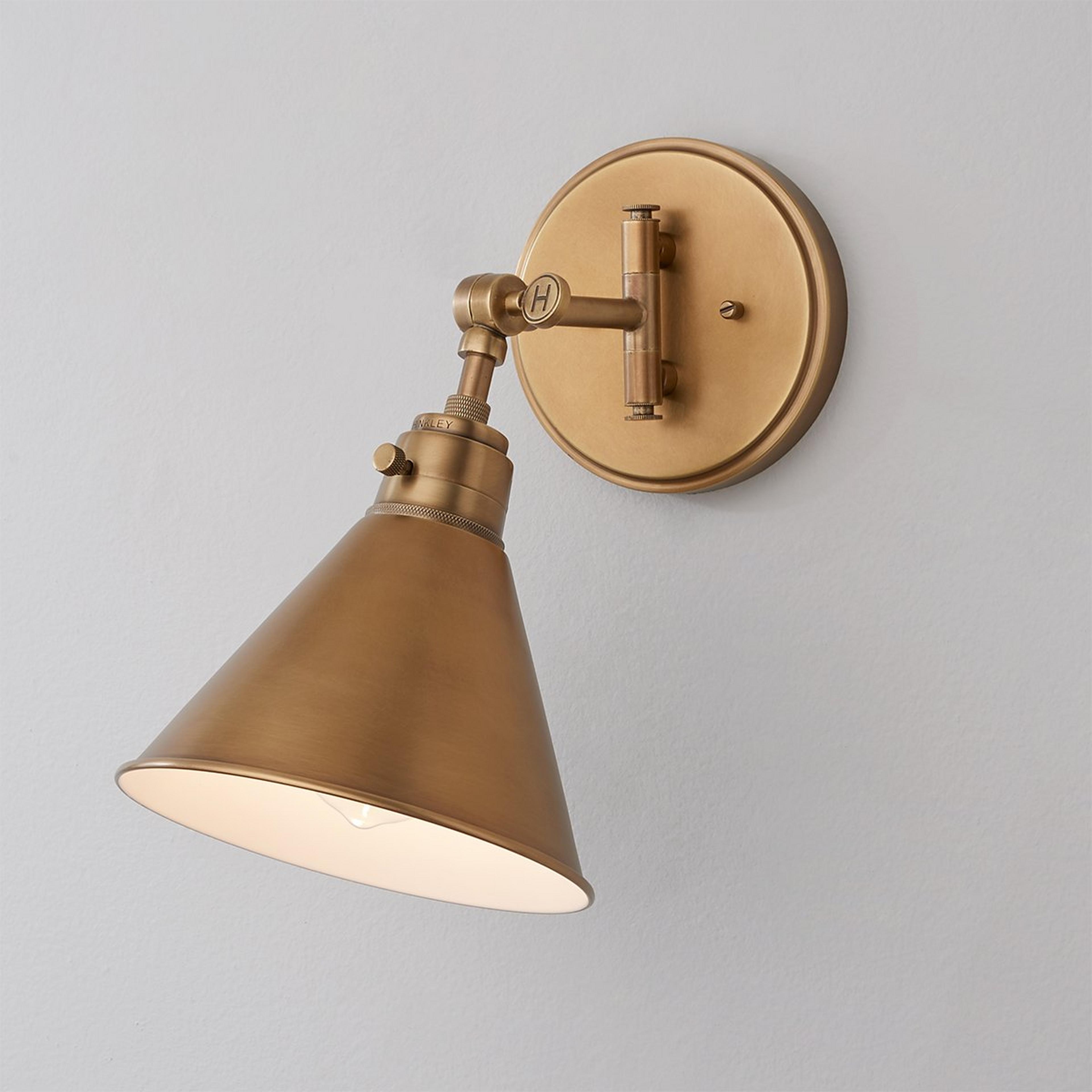 A Cyrus Swing Arm Sconce - Metal Shade with Aged Brass color